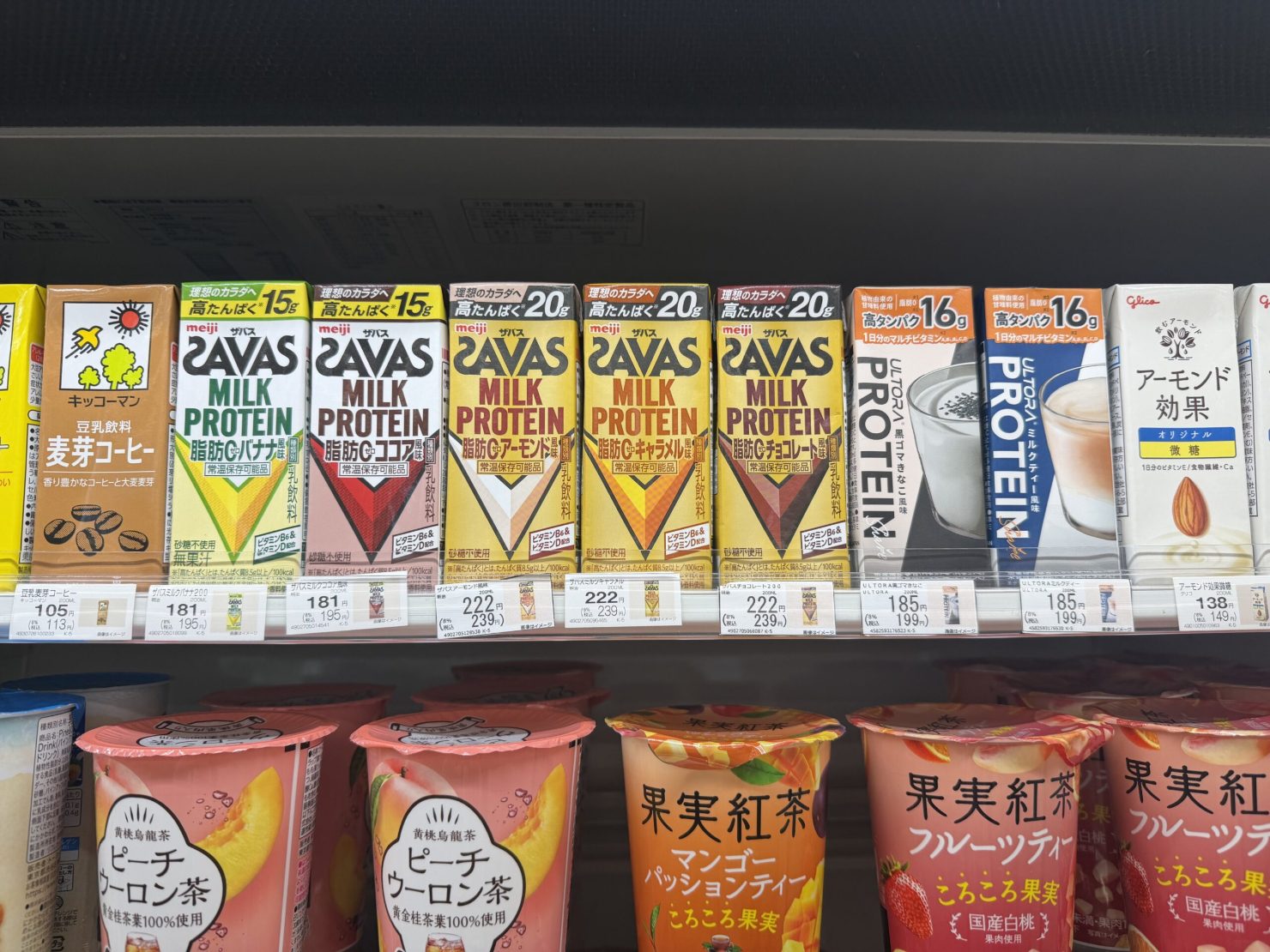 コンビニの冷蔵棚に並ぶザバス ミルクプロテイン(ココア・バナナ・アーモンド・キャラメル・チョコレート風味)などの高タンパク飲料