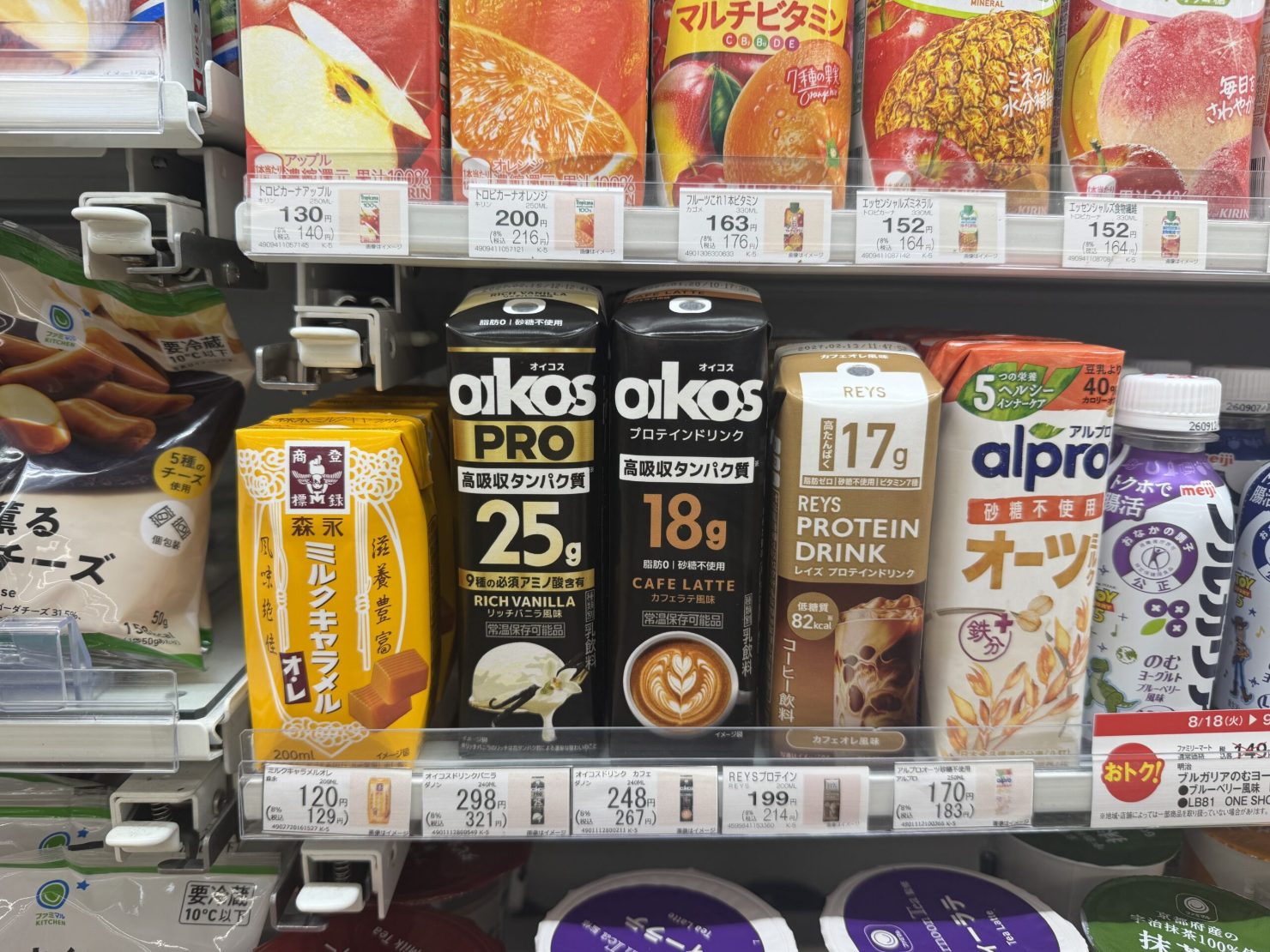 コンビニの冷蔵棚に並ぶオイコスPRO(リッチバニラ、タンパク質25g)やオイコス プロテインドリンク(カフェラテ風味、18g)などの高タンパク飲料
